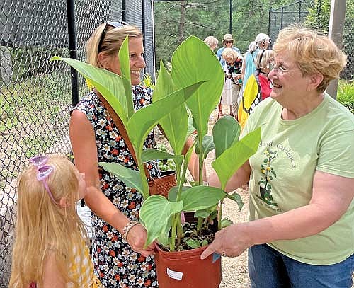 Kandace Lynn hands Laura Fiala and her daughter Amelia, left, a plant they bought during the inau- gural GardenFest event at the Aspirus Seasons of Life Hospice House on Saturday, July 22, in Woodruff. (Photo by Trevor Greene/Lakeland Times)