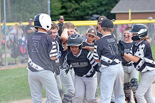 Taitum Bauman, center, celebrates with his teammates at home plate after a home run in the fourth inning against Wausau during a tournament Sunday, July 30 at 70 West Complex in Minocqua. Pictured, from left, are Caleb Karch, Parker Ecklund, Owen Sauer, Levi Eslinger, William Schuman, Robert Blohm, Logan DeGolier and Emmit Gee. (Photo by Brett LaBore/Lakeland Times)