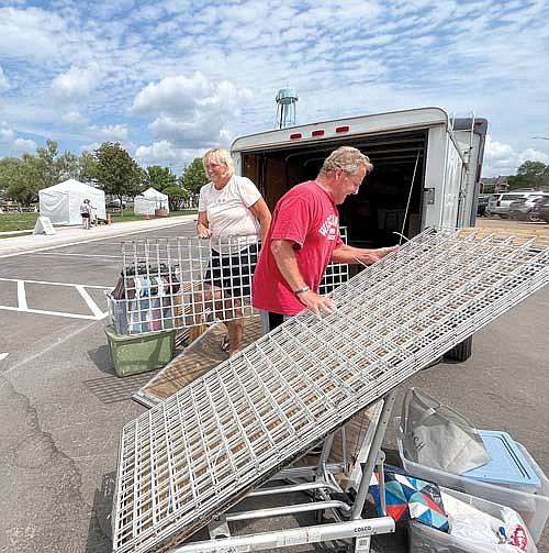 Bonnie and Tony Smith unload their equipment in preparation for the Aug. 3 After Loon Delight Craft Show at Torpy Park on Wednesday, Aug. 2, in Minocqua. (Photo by Trevor Greene/Lakeland Times)