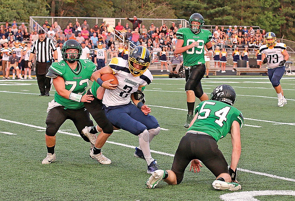 In this Aug. 19, 2022 file photo, Tomahawk quarterback Tyler Jablonski attempts to get out of a tackle attempt by Rhinelander’s Carter Krueger with Rhinelander’s Conner Jensen (73) and Bo Stott (54) in pursuit during the second quarter of a non-conference football game at Mike Webster Stadium. Tomahawk won last year’s opener 27-13, and both teams are look to start 2023 on the right foot tonight following injury-plagued 2022 campaigns. (Bob Mainhardt for the River News)