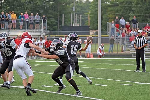 Kort Meyer throws a touchdown pass to Maccoy Holmquist as Isaac Olson (63) blocks his defender in the first quarter of the season opener vs. Wausau East Friday, Aug. 18 at IncredibleBank Field in Minocqua. (Photo by Brett LaBore/Lakeland Times)