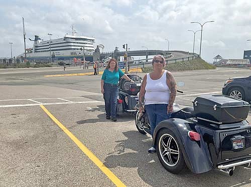 Colette Welch, left, and her friend Katherine Bakken pose for a photo with their motorcycles before getting on a ferry in North Sydney, Nova Scotia. (Contributed photograph)