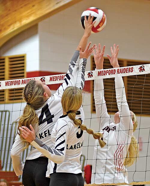Stina Peterson (4) and Meela Khan (3) reach for the ball against Medford’s Shayla Radlinger in the third set Thursday, Aug. 31 at Raider Hall in Medford. Peterson got the tip for a point. (Photo by Brett LaBore/Lakeland Times)