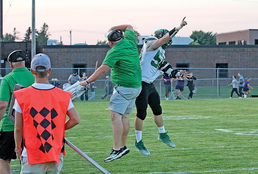 Rhinelander High School football coach Aaron Kraemer and center Kaeden Piller celebrate following a touchdown during the second quarter of a GNC football game at Ashland Friday, Sept. 1. The Hodags are 3-0 to start the season and will face another surprising 3-0 squad tonight as they host Hayward at Mike Webster Stadium. (Bob Mainhardt for the River News)