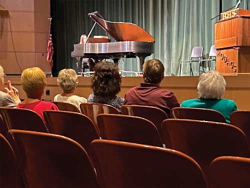 Dori Brown (in green) listens while Andrea Sheppard plays the Steinway piano refurbished as a result of the Brown family’s many contributions to the School District of Rhinelander’s performing arts program. A special ceremony honoring Brown was held in the John and Dori Brown Performing Arts Center at Rhinelander High School on Friday, Sept. 1, 2023. (Photo by Heather Schaefer/River News)
