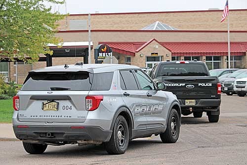 A Minocqua Police vehicle, front, and Woodruff Police vehicle are parked at the entrance of Minocqua Hazelhurst Lake Tomahawk school district on Friday, Sept. 29, in Minocqua. (Photo by Trevor Greene/Lakeland Times)