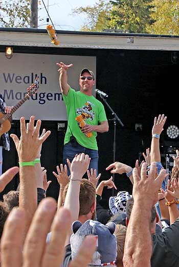 Lakeland Rotary stage emcee Fritz Wotruba throws a T-shirt into the Beef-A-Rama crowd. (Photo by Dean Hall/Lakeland Times)