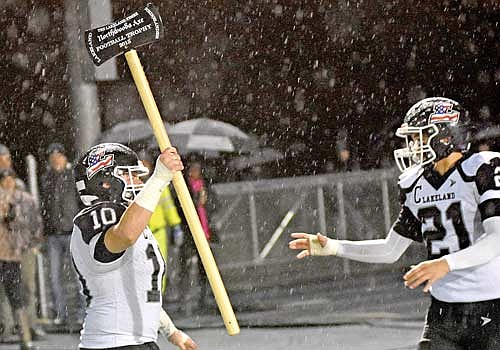 Leonard Chosa holds up the Northwoods Axe after a 32-6 victory over Rhinelander Friday, Oct. 13 at Mike Webster Stadium in Rhinelander. Fellow captain Talon Haling, right, helped Lakeland to end the season on a five-game win streak. (Photo by Brett LaBore/Lakeland Times)
