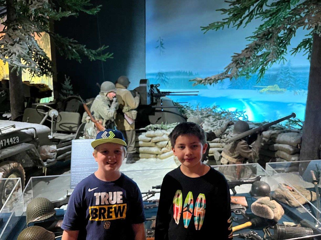 Lukas Lorenzen, left, and Derek Tecumseh in front of the “Battle of The Bulge” exhibit at the Wisconsin Veterans Museum. (Contributed photo)