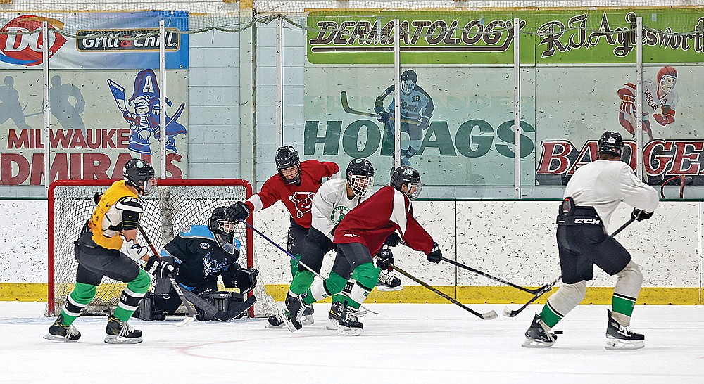 A group of players battle for the puck near the net during hockey captains’ practice. (Bob Mainhardt for the River News)