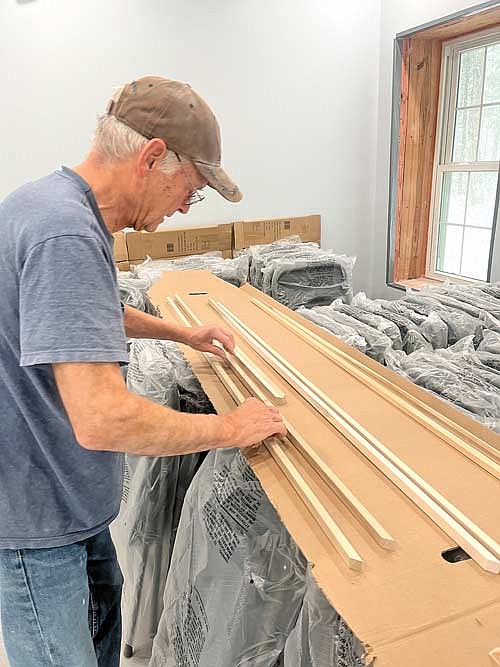 Larry Tinker organizes pieces of wood trim during the construction of a new Lake Tomahawk Bible Church building on Tuesday, Oct. 31, in Lake Tomahawk. (Photo by Trevor Greene/Lakeland Times)