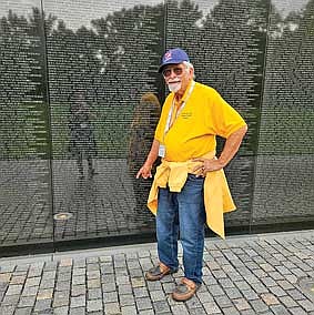 Air Force veteran Richard Draszkiewicz honors those who died at the Vietnam Memorial. (Photo by Renee Draszkiewicz/Lakeland Times)