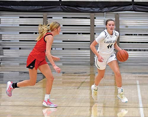 Kristina Ouimette dribbles the ball in the second half of the home opener against Shawano Tuesday, Nov. 21 at Ted Voigt Court in Minocqua. Ouimette led all scorers with 34 points while Shawano’s Leah Nordin, left, had 26 points to lead the Hawks. (Photo by Brett LaBore/Lakeland Times)