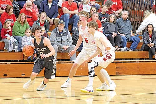 Jalend Cobb dribbles out of a pressing double team by Medford’s Charlie Gierl (5) and Hayden Koester in both teams’ conference opener Friday, Dec. 1 at Raider Hall in Medford. Cobb scored eight points in his season debut. (Photo by Matt Frey/Star News)