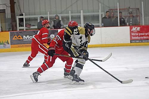 Gray Wagner skates towards the puck against Amery’s Taylor Gariepy in the second overtime Saturday, Dec. 2 at Lakeland Ice Arena in Minocqua. (Photo by Brett LaBore/Lakeland Times)