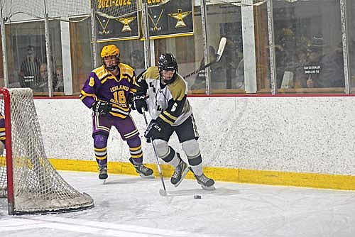Lawson Bain handles the puck with Ashland’s Carter Mika trailing in the first period of a 2-0 win Tuesday, Dec. 12 at Lakeland Ice Arena in Minocqua. (Photo by Brett LaBore/Lakeland Times)
