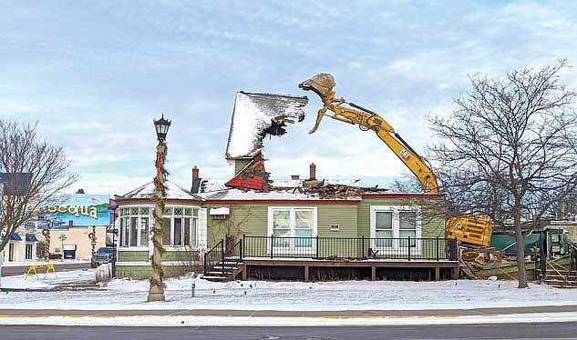 Schrom’s Excavating demolishes the Coach House Apartments mid-day on Monday, Dec. 18, in downtown Minocqua. (Photo by Dean Hall/Lakeland Times)