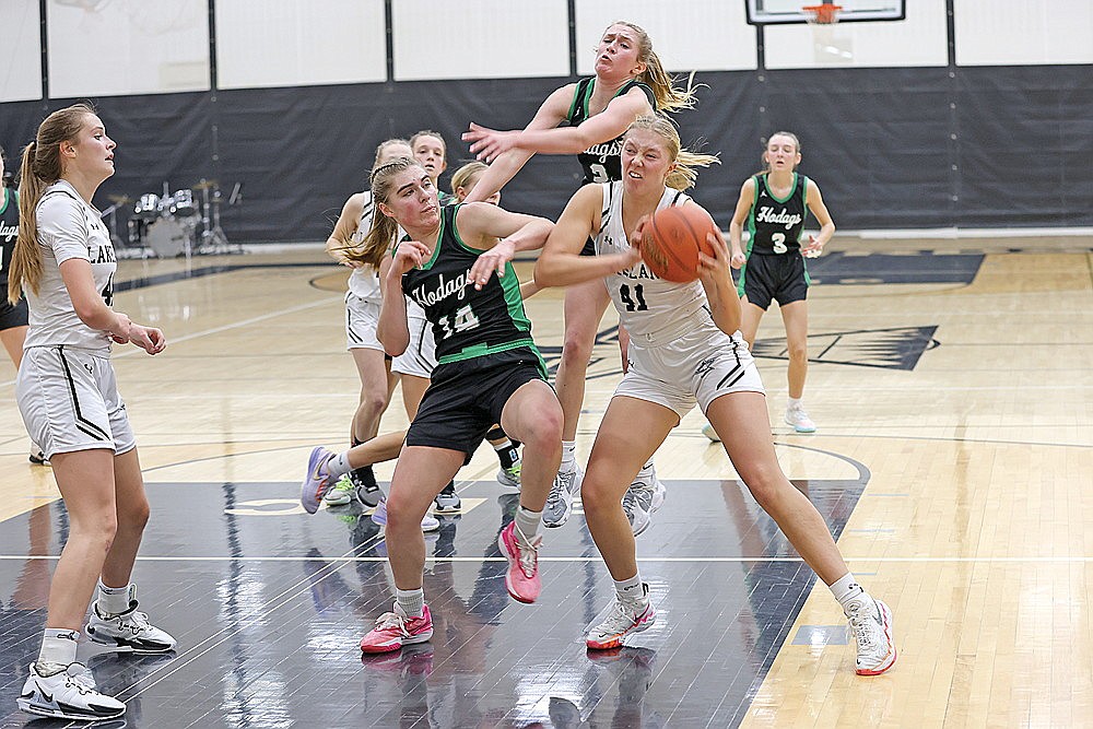 Lakeland’s Saylor Timmerman grabs a rebound in front of Rhinelander’s Lily Treder (14) and Vivian Lamers (2) during the second half of a GNC girls’ basketball game in Minocqua Friday, Jan. 5. Lakeland won the game, 77-34. (Bob Mainhardt for the River News)