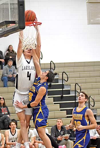 Hakken Berklund dunks the ball over Marion’s Enea Turrini in the second half of a 73-35 win Monday, Jan. 15 at Ted Voigt Court in Minocqua. Berklund led all scorers with 17 points. (Photo by Brett LaBore/Lakeland Times)