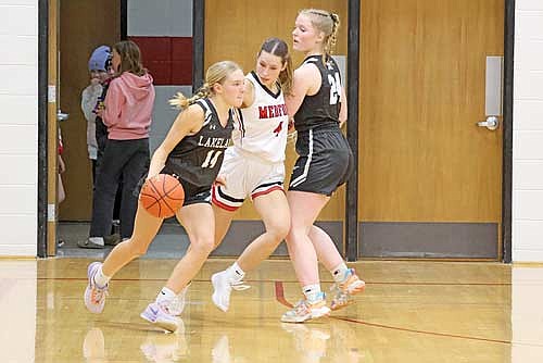Ali Timmerman dribbles around a screen from Cale Quade on Medford's Toryn Rau Friday, Jan. 19 at Raider Hall in Medford. (Photo by Matt Frey/Star News)