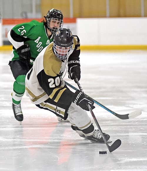 Brent Olson handles the puck with Rhinelander’s Timber Cronauer watching in the second period Thursday, Jan. 25 at Lakeland Ice Arena in Minocqua. (Photo by Brett LaBore/Lakeland Times)