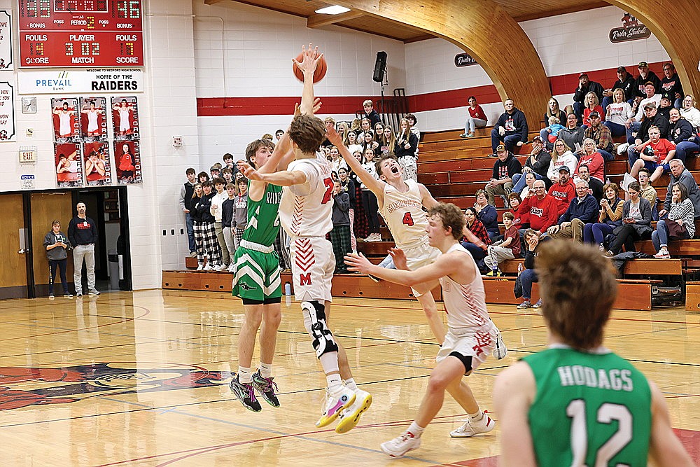 Rhinelander’s Devon Feck hits a game-tying 3 over Medford’s Hayden Koester (23) and Nick Steliga (4) late in the second half of a GNC boys’ basketball game in Medford Thursday, Feb. 1. Feck had a team-high 18 points for the Hodags in the contest. (Bob Mainhardt for the River News)