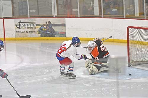 Taylor Heleniak scores the puck past Viroqua goalie Sami Bramstedt in the third period of a 2-1 win in double overtime Friday, Feb. 9 at Lakeland Ice Arena in Minocqua. Heleniak had the game-winning assist in her final game on home ice. (Photo by Brett LaBore/Lakeland Times)