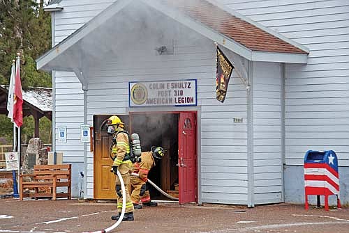 Firefighters work to get hoses inside the building that houses the Colin F. Schultz American Legion Post 318 in Lake Tomahawk on Tuesday, Feb. 13, 2024. (Photo by Brian Jopek/Lakeland Times)