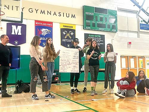 A group of Rhinelander High School students hold up a sign listing challenges facing young people as part of a leadership workshop with nationally recognized speaker JC Pohl Thursday, Feb. 8, 2024 in the Jim Miazga Community Gymnasium. (Photo courtesy of School District of Rhinelander)