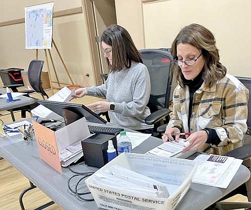 Minocqua poll workers Genea Rotar, left, and Stacy Baker process absentee ballots during the primary on Tuesday, Feb. 20. (Photo by Brian Jopek/Lakeland Times)