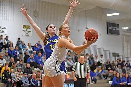 Saylor Timmerman attempts a layup against the defense of Rice Lake’s Addison Schmidt in the second half of a WIAA Division 2 regional final game Saturday, Feb. 24 at Ted Voigt Court in Minocqua. Timmerman scored 16 points. (Photo by Brett LaBore/Lakeland Times)