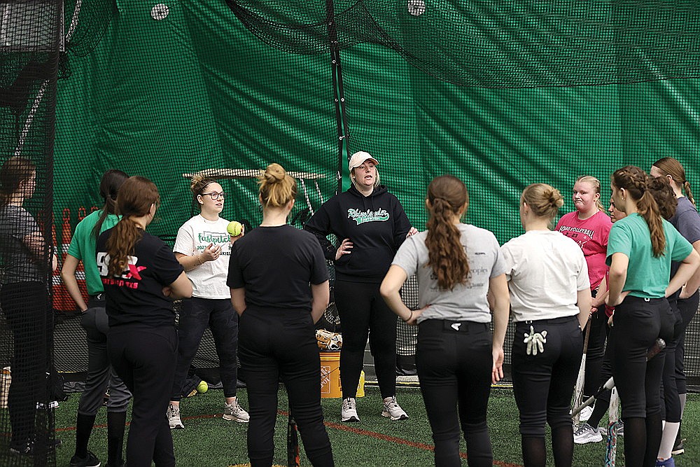 Rhinelander High School softball coaches Sadie Adamski, left, and Ali Bender, center, address their team following practice in the Hodag Dome Monday, March 11. Monday marked the first day of practice for high school softball teams in Wisconsin. (Bob Mainhardt for the River News)