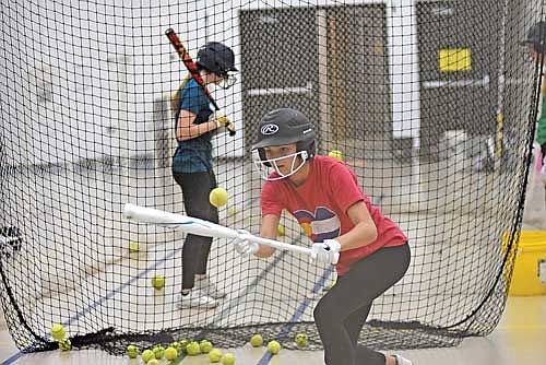 Malia Newport practices bunting during the first day of practice Wednesday, March 13 at the Lakeland Union High School fieldhouse in Minocqua. Newport was part of the Lakeland 14U championship team last summer. (Photo by Brett LaBore/Lakeland Times)