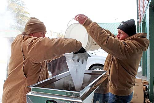 Camp American Legion director Jim Klement, left, holds a filter while volunteer Jim Ebert pours sap into an evaporator to make maple syrup on Thursday, March 21, in Lake Tomahawk. (Photo by Trevor Greene/Lakeland Times)