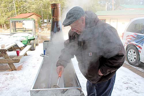 Veteran volunteer Jim Busko skims the top of boiling sap while making maple syrup at Camp American Legion on Thursday, March 21, in Lake Tomahawk. (Photo by Trevor Greene/Lakeland Times)