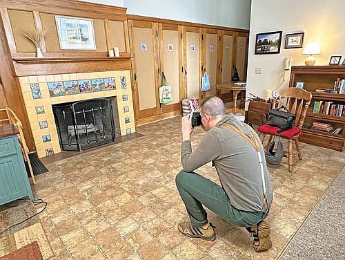 Milwaukee art teacher and tile artist Ben Tyjeski photographs historic tile art surrounding the fireplace in the former kindergarten classroom at Historic West Elementary in Rhinelander on March 22, 2024. The building, constructed in 1924, served as an elementary school for many years before being converted into an apartment complex in 2007. Tyjeski also photographed historic tiles at Central Elementary and met with students there as part of his Rhinelander visit. (Photo by Heather Schaefer/River News)
