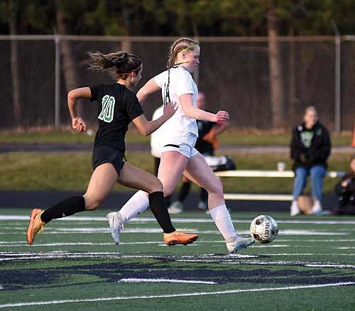 Cale Quade controls the ball followed by Rhinelander’s Lindsey Hoerchler in the first half Tuesday, April 30 at Mike Webster Stadium in Rhinelander. The Thunderbird defense posted their fourth conference shutout of the season. (Photo by Brett LaBore/Lakeland Times)