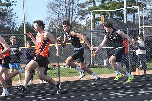 Gavin Saunders hands the baton off to Scott LaBarge in the 4x100-meter relay at the Lakeland Invite Tuesday, April 30 at IncredibleBank Field in Minocqua. (Photo by Brett LaBore/Lakeland Times)