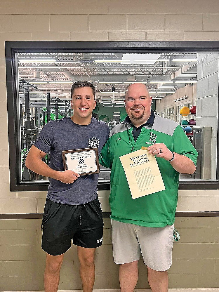 James Heck and RHS football coach Aaron Kraemer pose with Heck’s plaque and letter of recognition from the WFF for being selected as a nominee. (Photo courtesy of Rhinelander Hodag Athletics & Activities/Facebook)