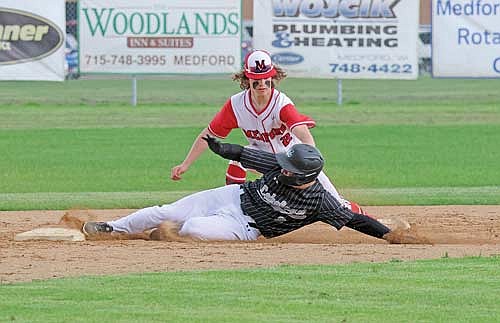 Landon Herrick slides in safely with a stolen base as Medford’s Ryder Kraschnewski applies a late tag in the third inning Thursday, May 9 at Raider Field in Medford. (Photo by Matt Frey/Star News)