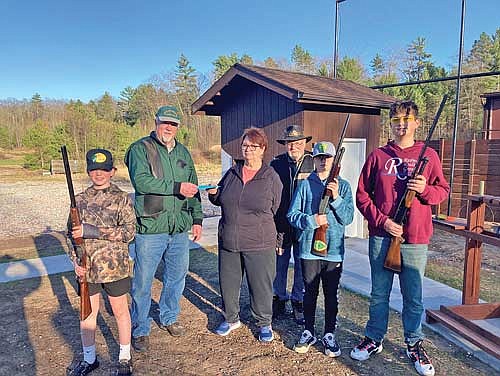 Boulder Junction Shooting Range board of directors member Dave Wakeman accepts a donation for youth shooting programs by Jane Manske, in honor of her husband Mike. Also pictured, to the right of Jane, is board of directors member Bill Washburn. The three youth shooting program participants, from left, are Palmer Bain, Devin Friedley and Reid McClellan. (Contributed photograph)