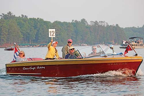 James Smith and friends make their way through the parade in a 1953 Chris Craft Holiday during the antique and classic boat parade at halftime of the Min-Aqua Bats Water Ski Show on Friday, June 16, 2023 in Minocqua. (Photo by Trevor Greene/Lakeland Times)