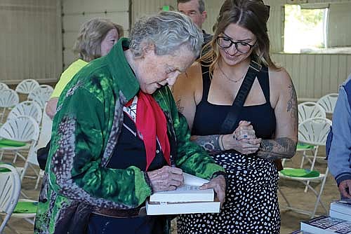 Alexandra Kuckkahn gets a book signed by Temple Grandin at Scholl Community Impact Group in Winchester. (Photo by Katie Reichl/Lakeland Times)