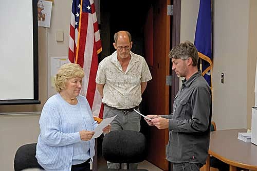 School board president Ron Counter, center, looks on as board secretary Mary Peterson administers the oath of office to new school board member Doug Artus on Monday evening, June 17, 2024 in the Superior Diesel Advanced Learning Center at Rhinelander High School. (Photo by Jeremy Mayo/River News)