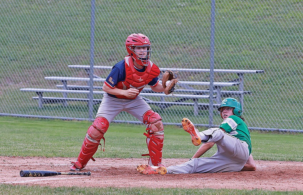 Rhinelander’s John Turek looks up after beating the tag of Northwoods’ catcher Griffin Beyer on a throw to the plate in the third inning of an American Legion baseball game at Stafford Field Wednesday, June 19. The Rebels scored their fourth straight victory, defeating the Eagles 11-1. (Bob Mainhardt for the River News)