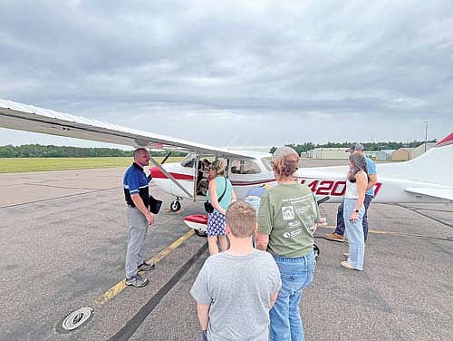 Jesse Birginal, left, speaks to a group of people about one of the trainer planes used by Lakeland Aviation flight instructors during a community fly-in event at the Lakeland Airport on Thursday, June 20, in Arbor Vitae. (Photo by Trevor Greene/Lakeland Times)