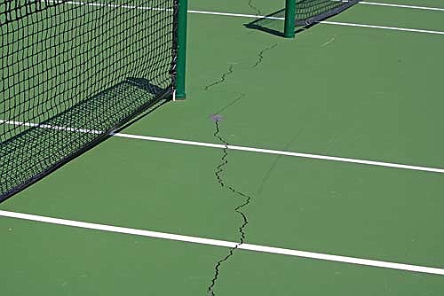 One of the cracks in the tennis courts at the Hazelhurst town park that town chairman Ted Cushing said pickleball players tried to fill themselves. (Photo by Mikey Rottier/Lakeland Times)