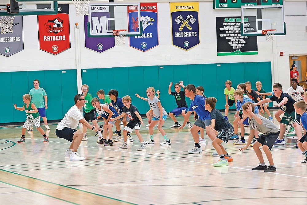 Rhinelander High School boys’ basketball coach Derek Lemmens works with campers on their defensive stance during Hodag Hoops Camp Monday, July 29 at the Jim Miazga Community Gymnasium. Lemmens said a record number of participants took part in this year’s camp, which ran Monday through Thursday, for youth basketball players entering grades 1-9. (Bob Mainhardt for the River News)