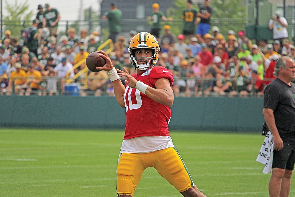 Quarterback Jordan Love throws the ball out of the pocket and on the run.