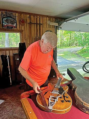 Ron Harrison, 77, of Presque Isle shows off a 1965 Guild Starfire guitar that he refinished himself and has used to perform all around the Lakeland area. (Photo by Mikey Rottier/Lakeland Times)